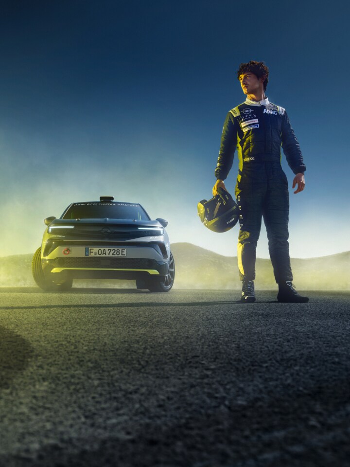 Vista anteriore di un Mokka GSE Rally con accanto un pilota Rally con il casco in mano